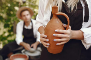 People making a vaze from a clay on a pottery's machine